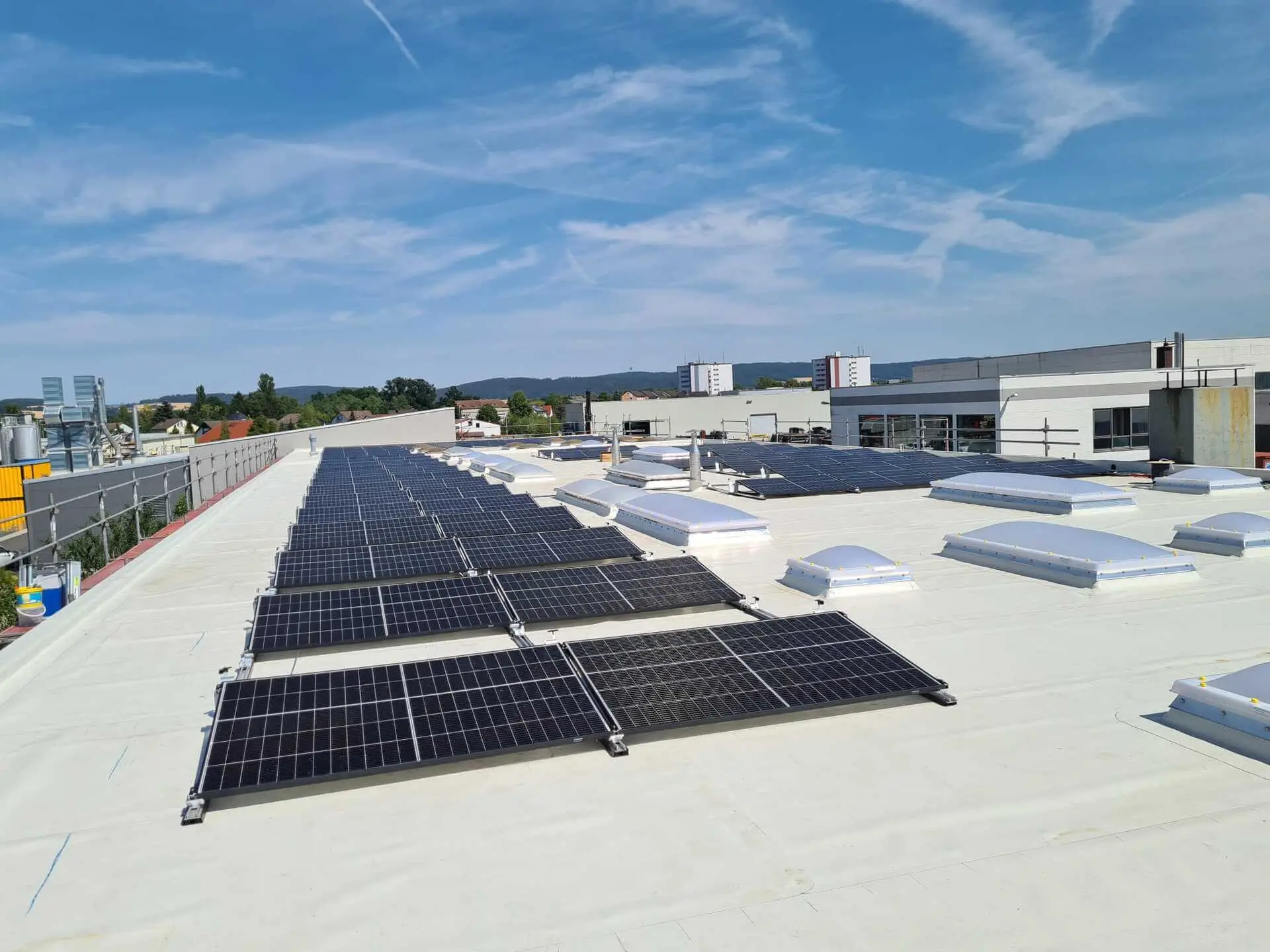 Aufgeständerte Module auf einem Flachdach mit Lichtkuppeln