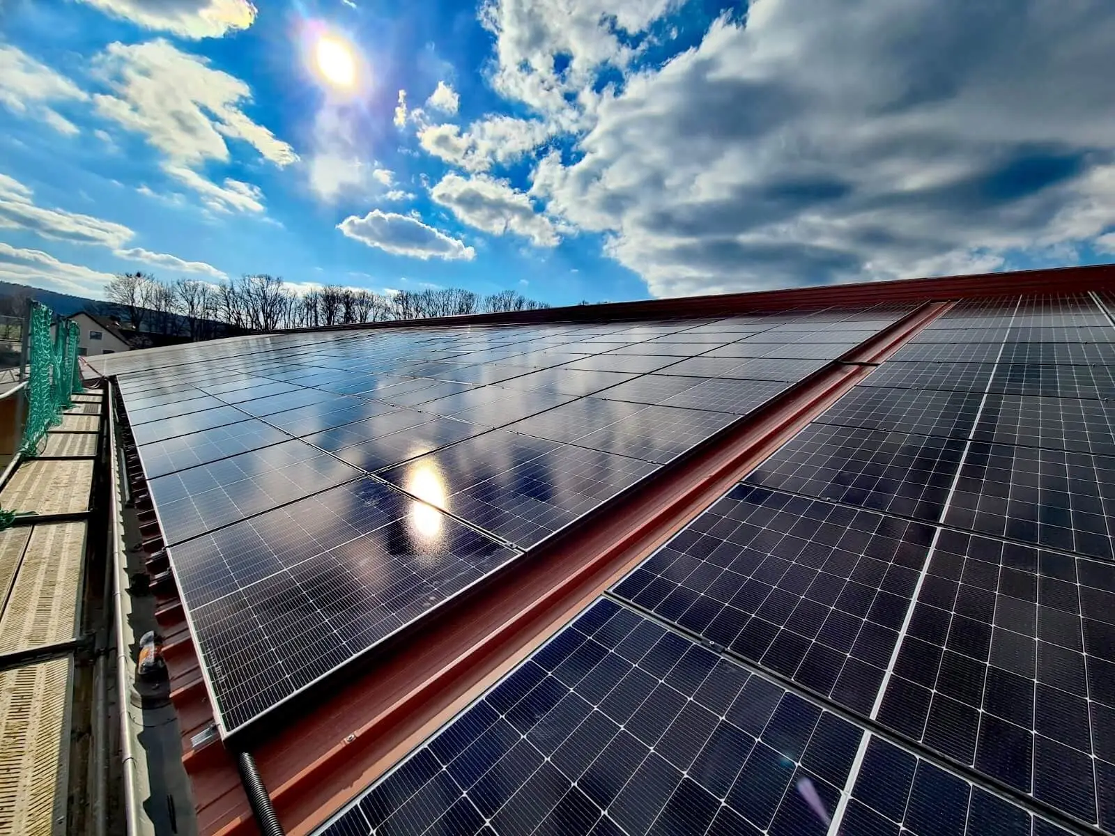 Hallendach mit Photovoltaik unter Wolkenhimmel