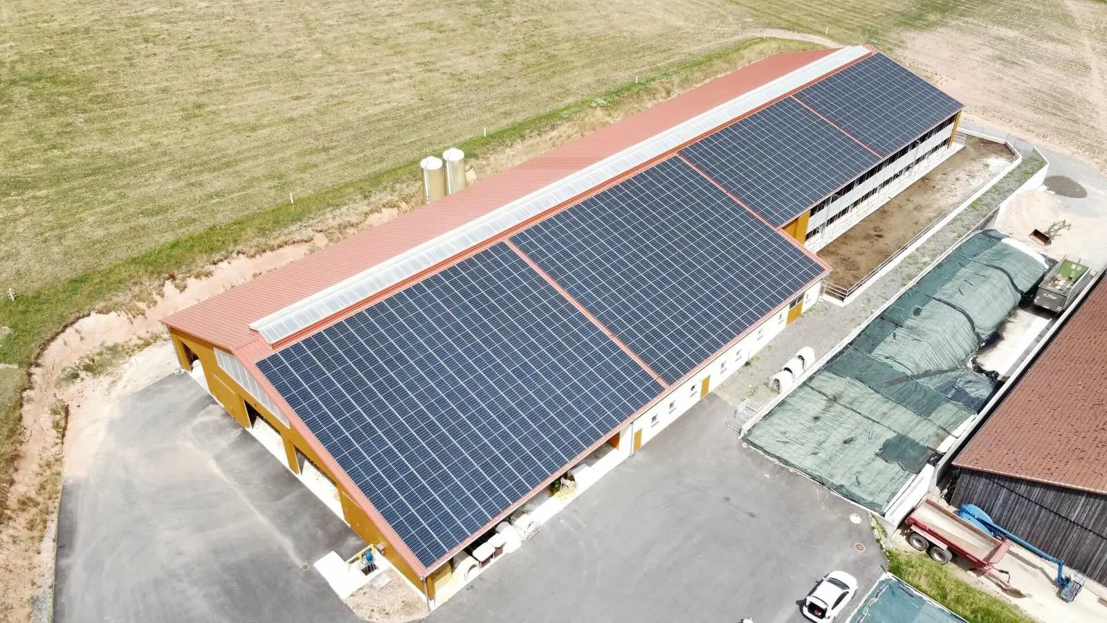 Luftaufnahme: Stall mit Photovoltaik auf der gesamten Dachfläche