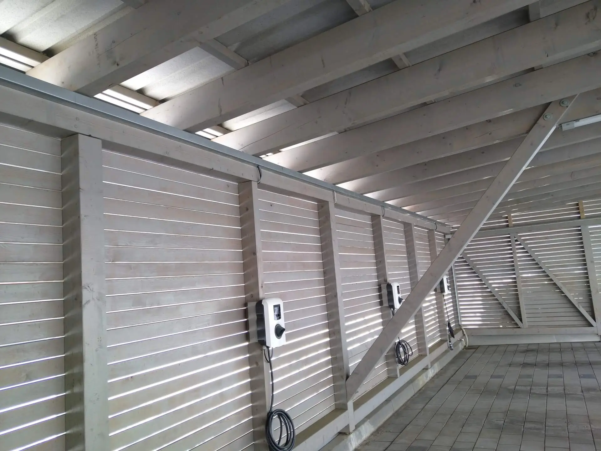 Drei Wallboxen an der Holzwand eines Carports